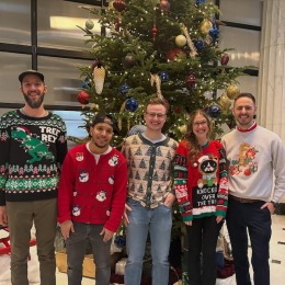 people standing in front of a Christmas tree