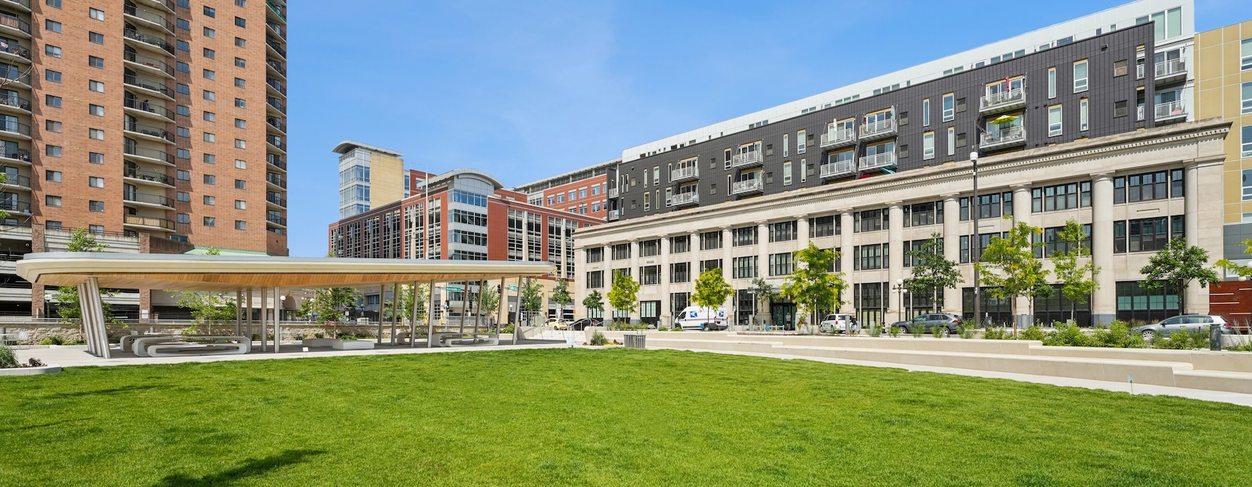 an open green space with buildings in the background