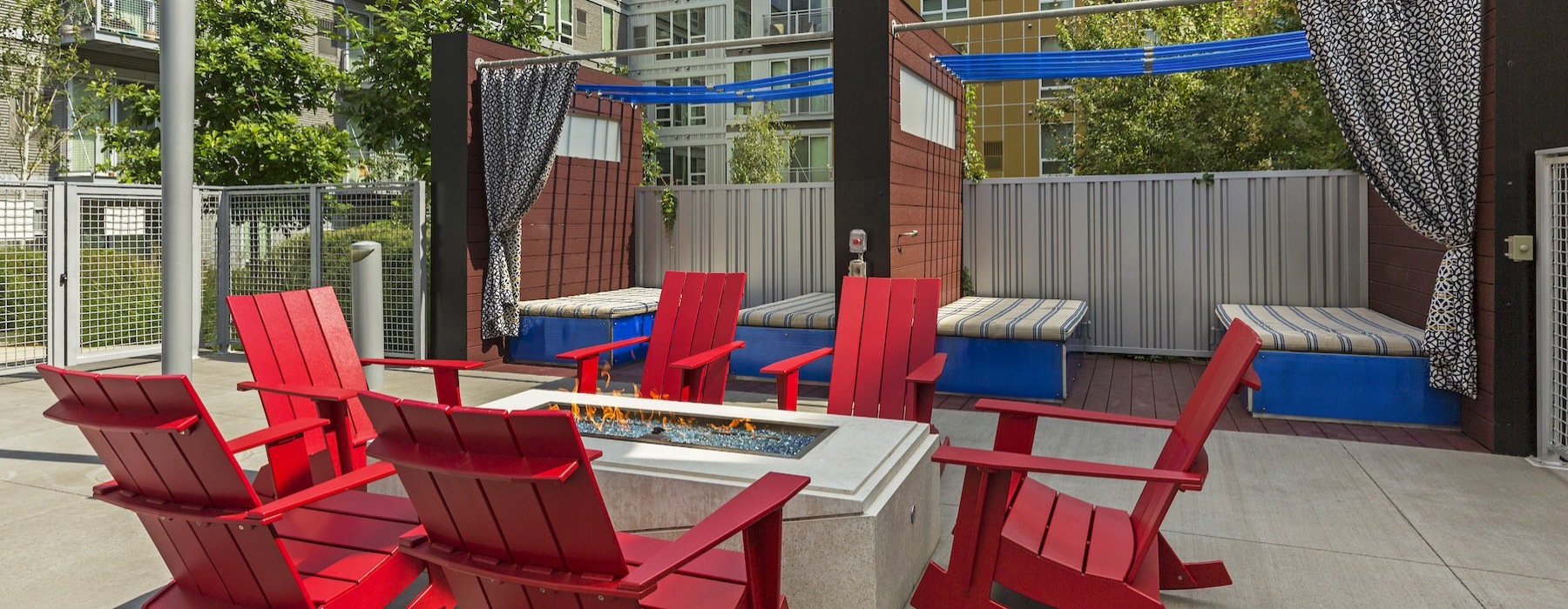 a fire pit with red chairs